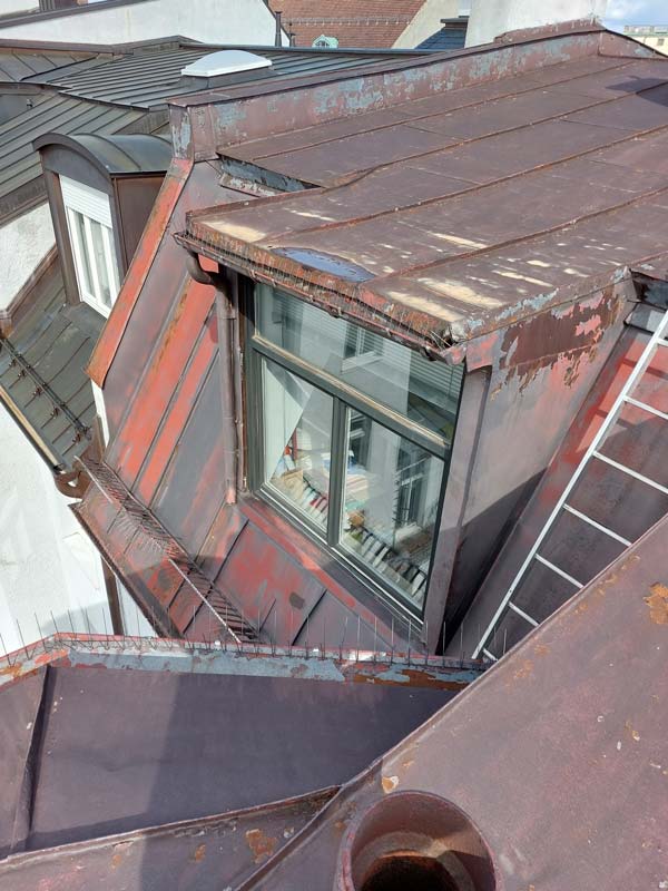 Ein Blick auf ein beschädigtes Metall- Blechdach, das dringend erneuert werden muss, um Leckagen und weitere Schäden zu verhindern.