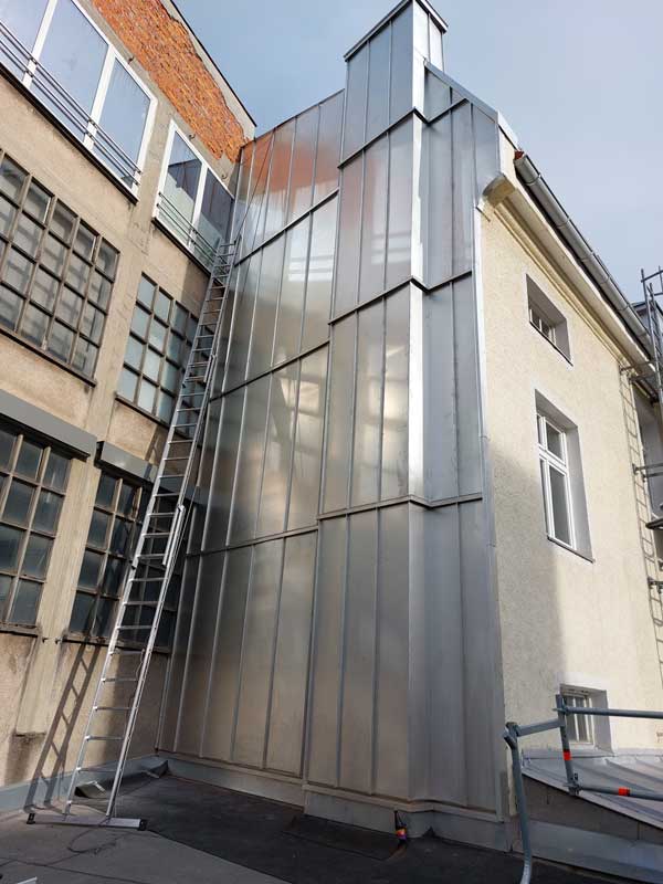 Meine professionelle Spenglerei Peter Schubert, München, schneidet präzise Metallplatten zu, um sie perfekt an die Fassade anzupassen und eine langlebige Lösung für die Fassadenverblendung zu bieten.